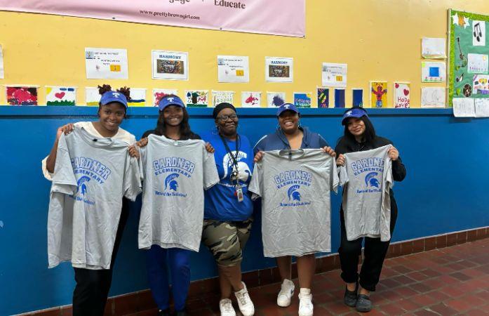 PTA members holding school shirts